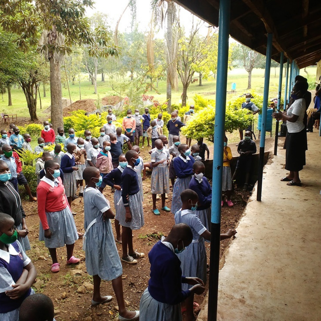 Talking to pupils of Kware Primary School before distribution of sanitary towels, underwear and facemasks.